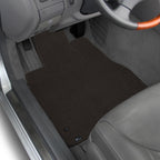 Car interior with a set of brown floor mats.