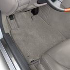 Car interior with gray floor mats covering the floor.