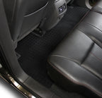 Car interior with gray leather seat and black floor mat.