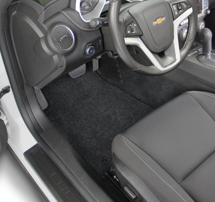 Car interior with steering wheel and dashboard, featuring a Chevrolet logo.