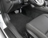 Car interior with a focus on the floor mat and pedals.