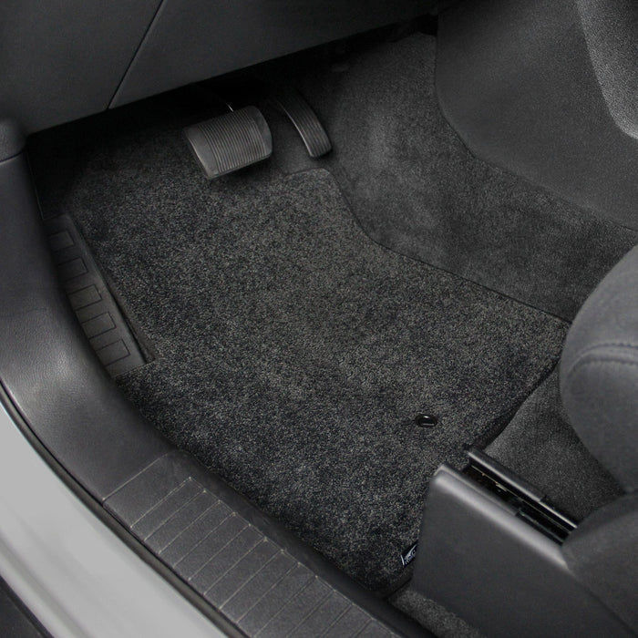 Car interior with gray floor mats covering the floor.