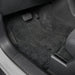 Car interior with gray floor mats covering the floor.