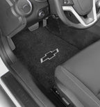 Car interior with black floor mats featuring a Chevrolet logo.