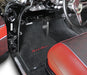 Car interior with black floor mats featuring 'Bel Air' text, red seat, and chrome accents.
