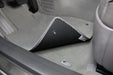 Car interior with a gray floor mat and a speaker grille.