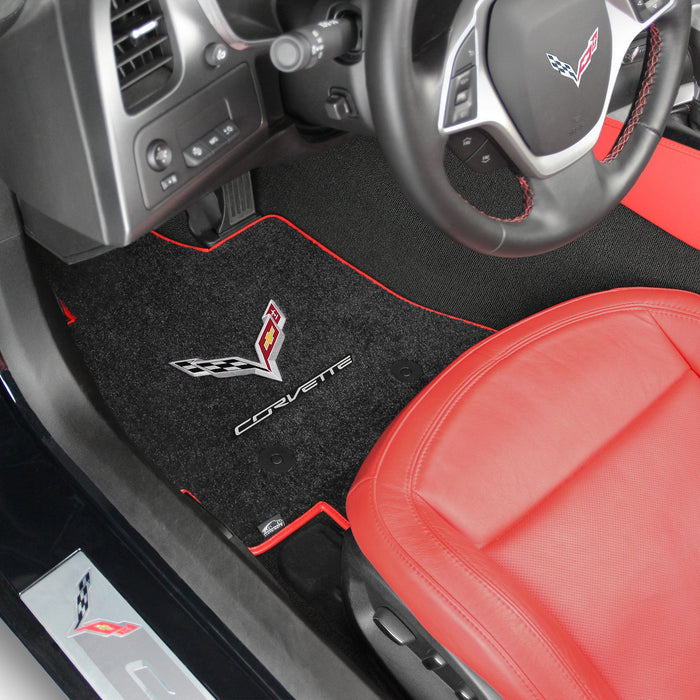 Car interior with black floor mats featuring Corvette logo and red seat