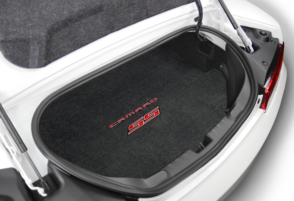 Car trunk with black floor mat featuring a red and white logo