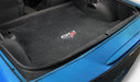 Car trunk with a black mat featuring a logo on a blue car