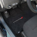 Car interior with black floor mats featuring the Dodge logo.
