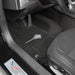 Car interior with a focus on the floor mat and pedals.