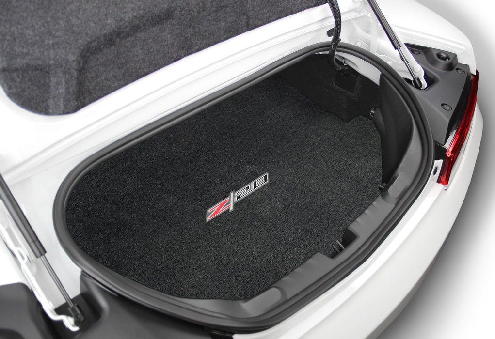 Car trunk with a black cargo mat featuring a logo on a white car background