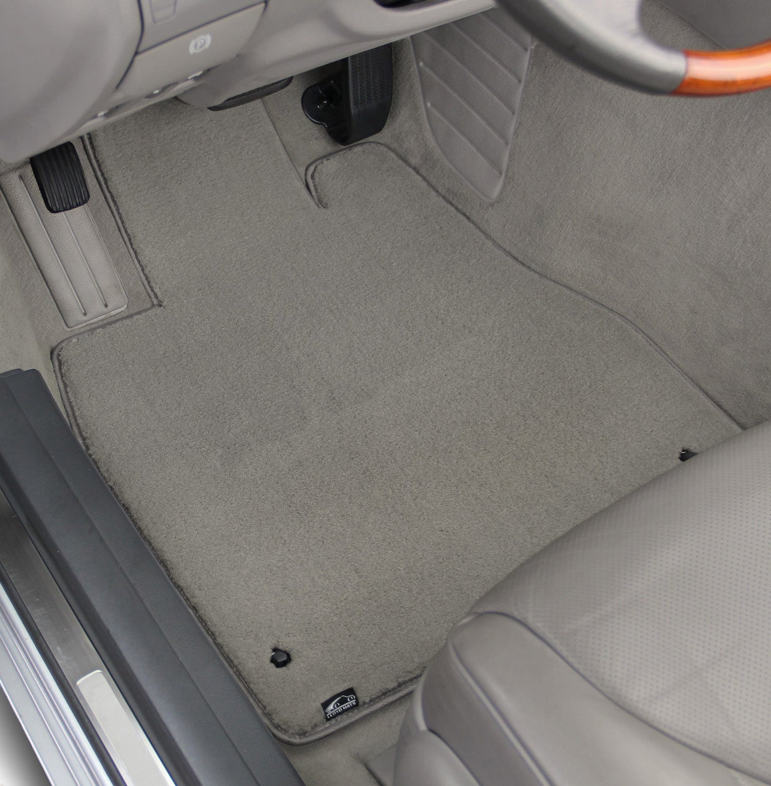 Car interior with gray floor mats and visible brand logo.