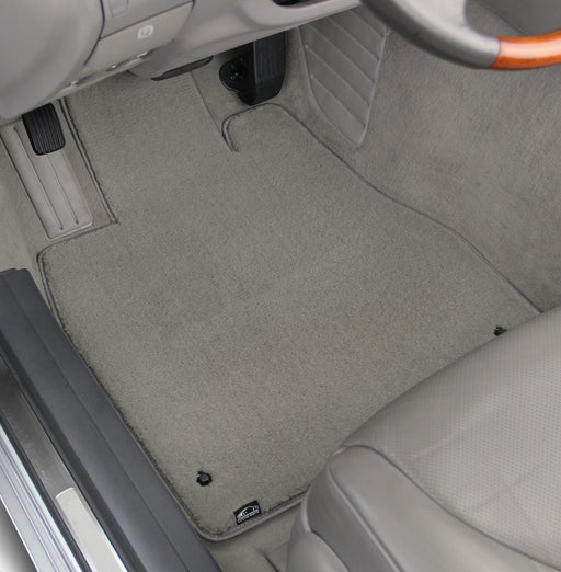 Car interior with gray floor mats and visible brand logo.