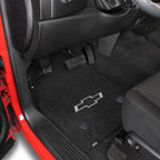 Car interior with black floor mats featuring a Chevrolet logo.