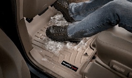 Boots with snow on a floor liner