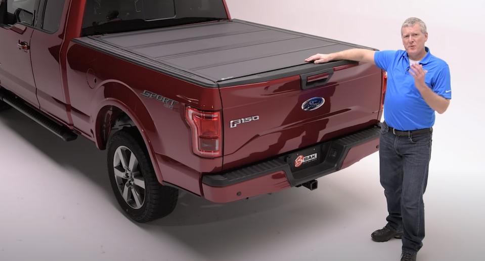 Someone touching a BAKFlip MX4 installed over a truck bed