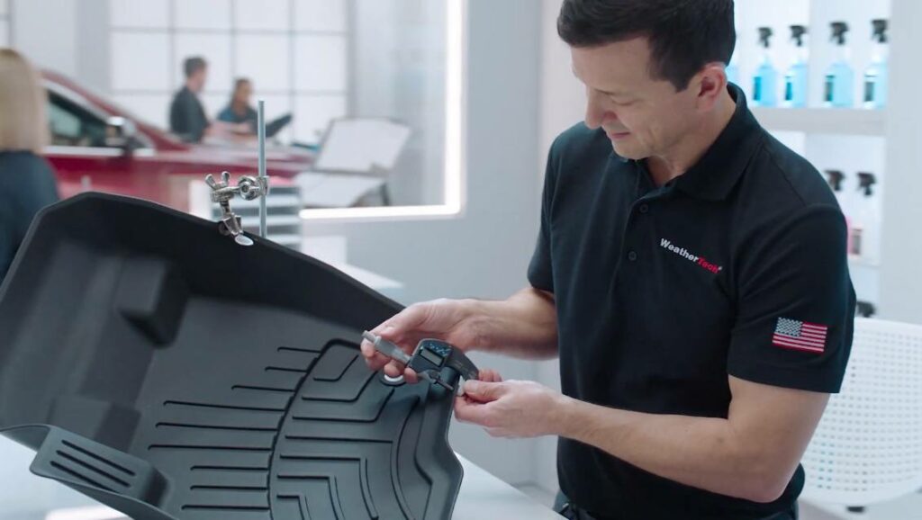 Technician checks out one of the heavy-duty all-weather floor mats from a truck