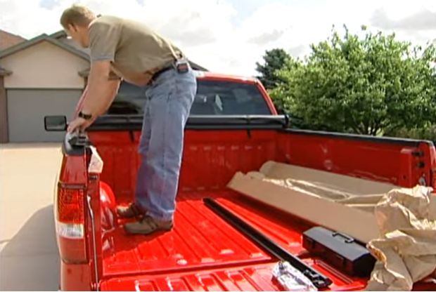 Man putting side rails on the truck bed rails