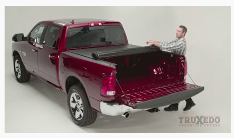 Man unrolling the Ram cover to close it