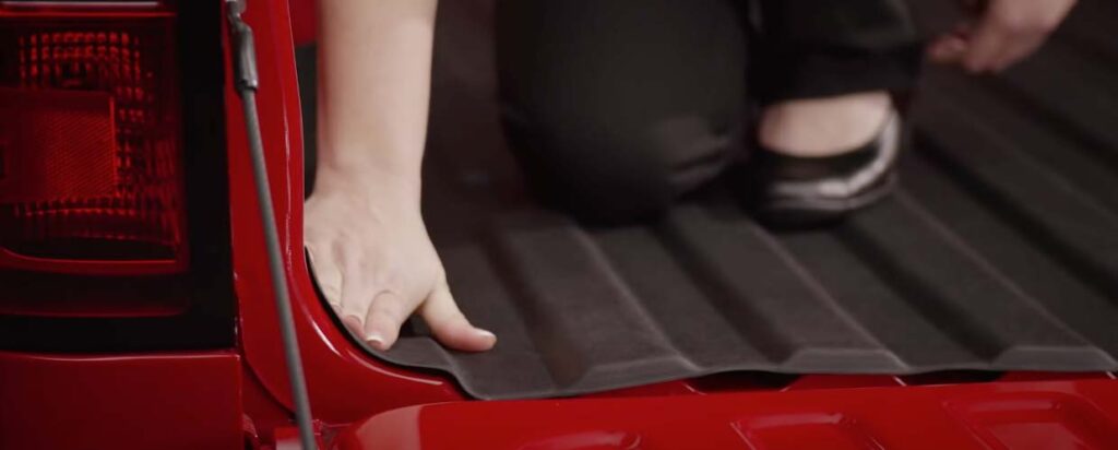 Edges of a WeatherTech Bed Liner installed on the bed of a red pickup truck