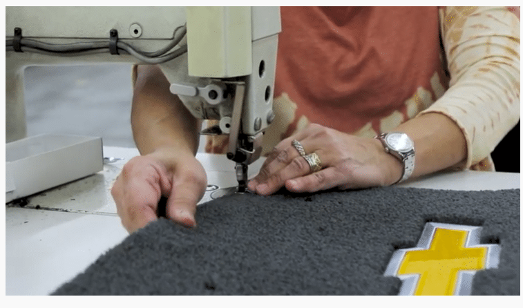 Woman sawing Lloyds Mats using quality yarns