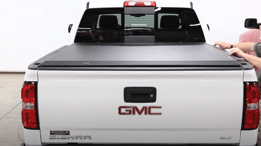 Someone installing Access Limited tonneau on a GMC truck